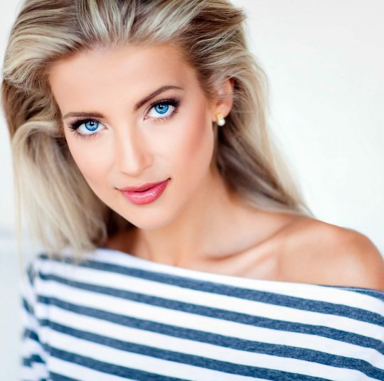 very beautiful, sensual sexy blonde girl with blue eyes in a striped dress, close up